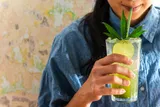 Woman drinking a THC beverage with a straw 