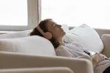 person laying on the couch sleeping with headphones on