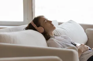person laying on the couch sleeping with headphones on