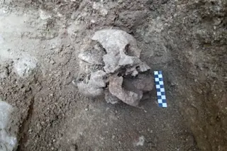 child skull with rock in mouth