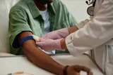 a nurse prepping a patient to have their blood drawn from their arm