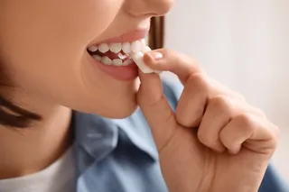 Woman bites into gum, anticipating cooling sensation caused by menthol. 