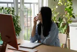 woman starting out the window instead of working 