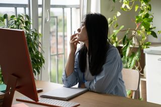 woman starting out the window instead of working