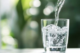 clean watered being poured into a glass clean watered being poured into a glass