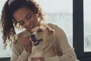 A woman cuddles her helpful dog