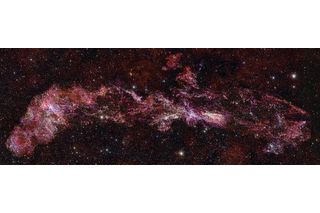 image spanning the milky way in vibrant red stars and gas 