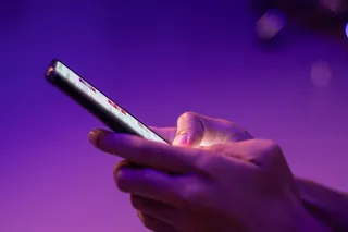 Person using their smartphone, possibly scrolling the ads