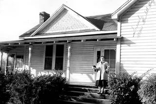 Ann Hodges standing outside of her home holding the meteorite that struck her.