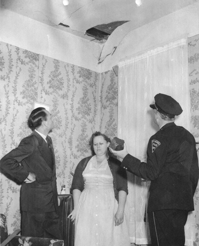 Hodges and other looking at a hole in the celling caused by a meteorite