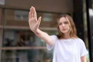 Woman holding her hand out to gesture stop