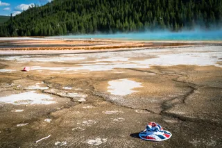 a red, white, and blue bucket hat in the Grand Prismatic Spring in Yellowstone 