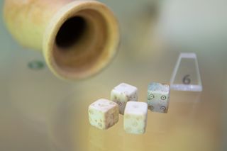 ancient stone cup and white dice 