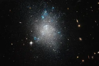 Dwarf galaxy NGC 5477, and galaxies in the background