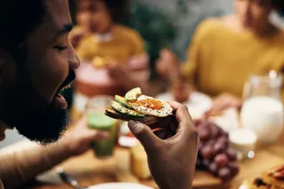 Eggs and cholesterol: what science got wrong. Man eating avocado toast with egg on it 
