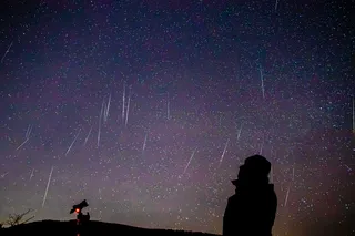 a silhouette of a person watching a meteor shower, an example of the Lyrid meteor shower