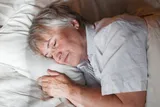 Person laying down in bed and taking a nap