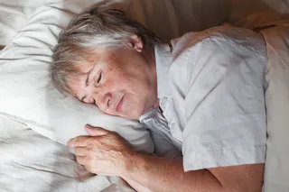 Person laying down in bed and taking a nap