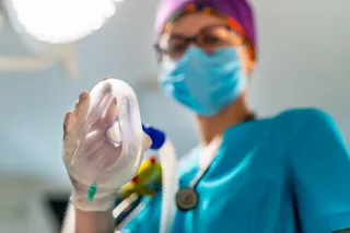 nurse holding an anesthesia mask 