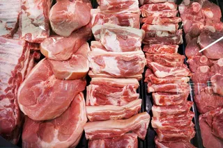 Raw red meat cuts displayed in a butcher shop as researchers examine links between red meat consumption, human evolution, and modern health risks.