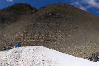 Field team members examine ancient rock layers at Grotto Creek in Alaska’s Wrangell–St. Elias National Park, where researchers studied evidence of ocean oxygen loss before the end-Triassic extinction.