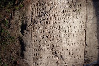 old runes carved into a large white stone 