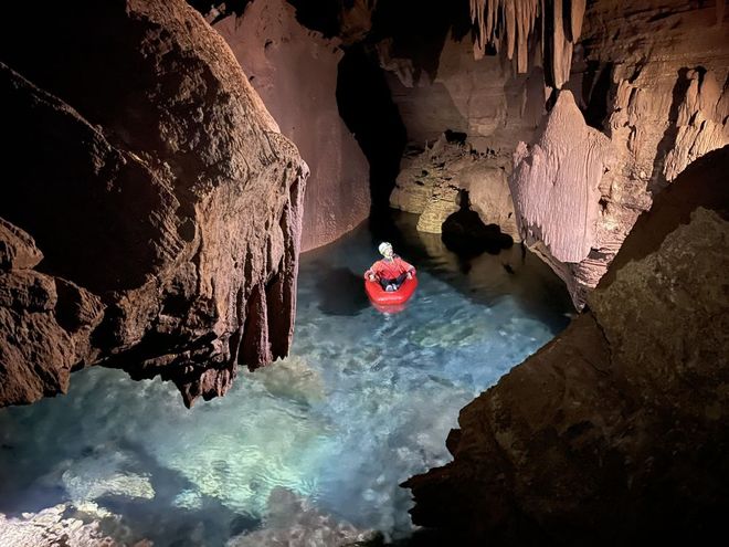 Person in inflatable kayak in underground pond inside the Grand Canyon 
