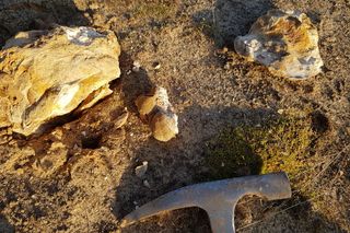 hammer near pieces of rock 