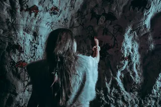 primitive person drawing in a cave 