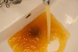 brown water in a white sink