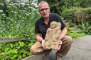 professor holding an ancient roman statue 