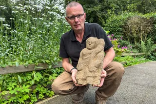 professor holding an ancient roman statue