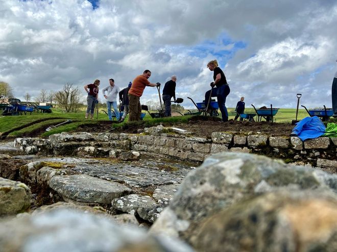 researchers excavating a dig site 