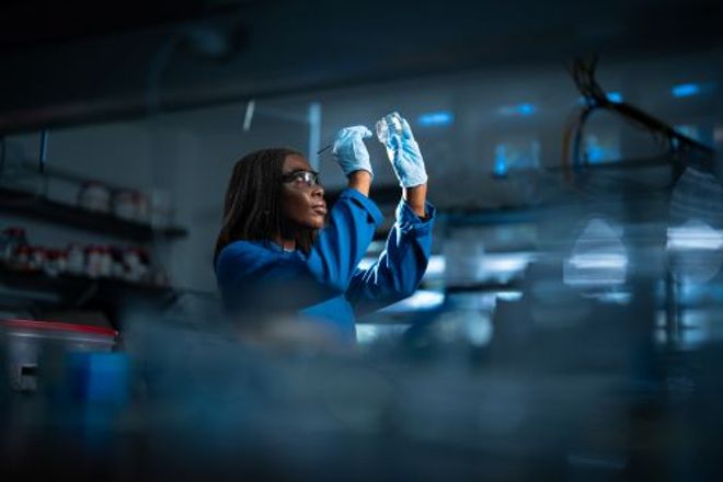 A researcher examines a zinc oxide mineral sunscreen sample in a lab.