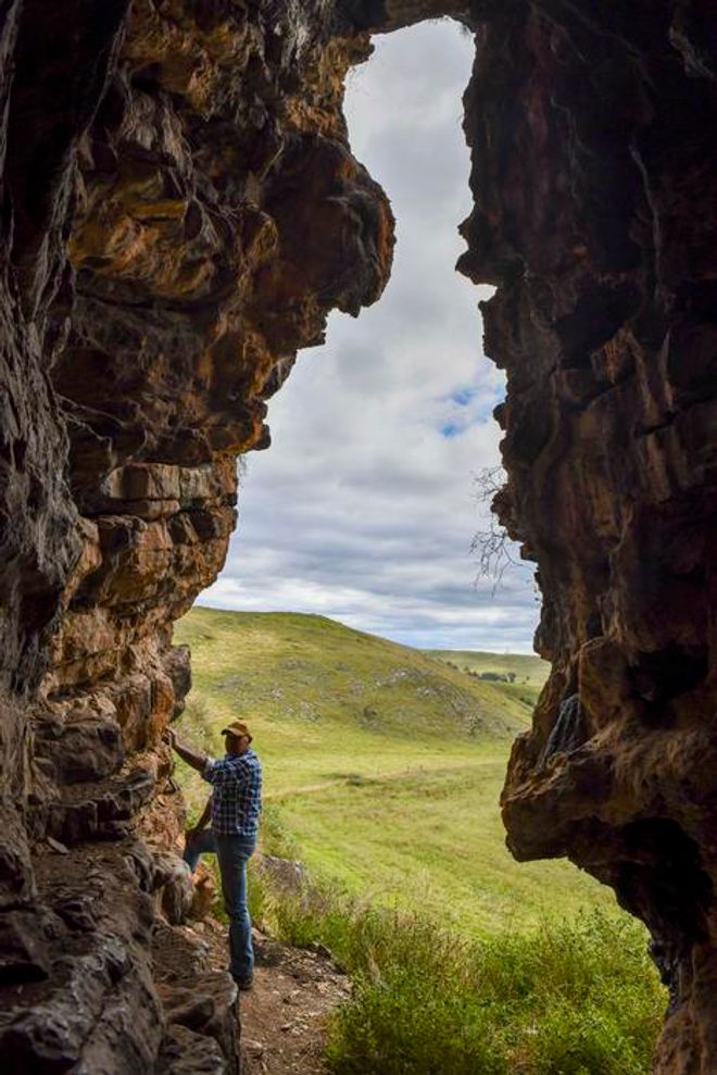 GunaiKurnai Elder Uncle Russell Mullett standing at the entrance of Cloggs Cave