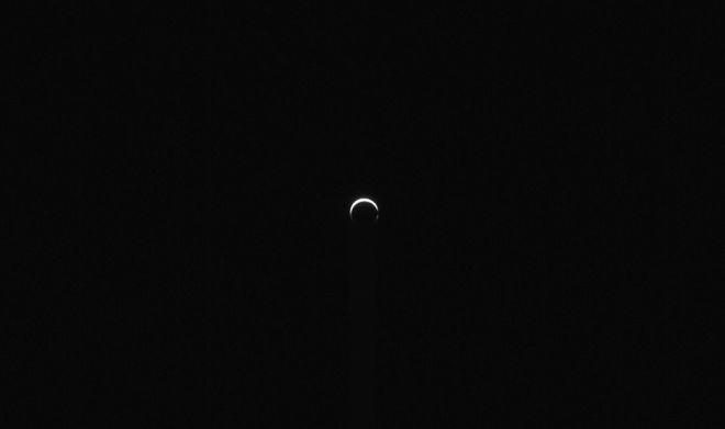 small, bright crescent of Mars in the distance small, bright crescent of Mars in the distance