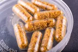 several clear fecal transplant pills with brown material inside 