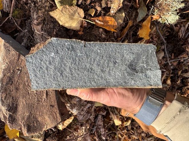 A hand holds an impact melt rock sample from Quebec’s 390-million-year-old Uhackatik meteorite crater. A hand holds an impact melt rock sample from Quebec’s 390-million-year-old Uhackatik meteorite crater.