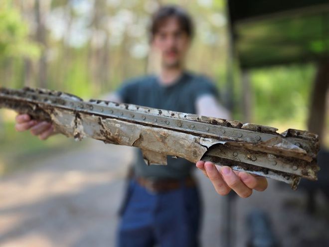 person holding a fragment of the plane 