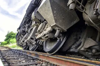 close up of train wheels on a derailed train