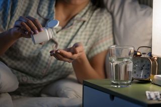 Person takes melatonin pills before bed to fall asleep