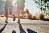 two people jogging up a paved hill 