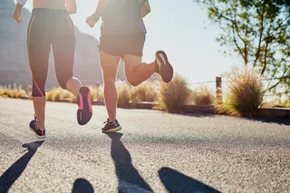 two people jogging up a paved hill