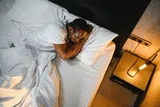 Person sleeping in a hotel room on a trip 