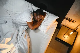 Person sleeping in a hotel room on a trip 