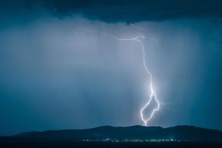 Bolt of lightning striking over a small town
