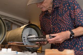 A researcher inserts pottery samples into a thermal demagnetizer.