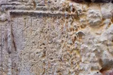 Weathered ancient stone surface carved with Latin inscriptions.
