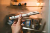 person holding a GLP-1 pen