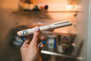 person holding a GLP-1 pen